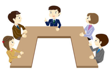 Sono raffigurate delle persone sedute attorno ad un tavolo a forma di 